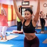 Women practicing yoga in a well-lit indoor studio, focusing on fitness and mindfulness.