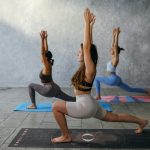 Three women engaging in a yoga session, focusing on health and mindfulness.
