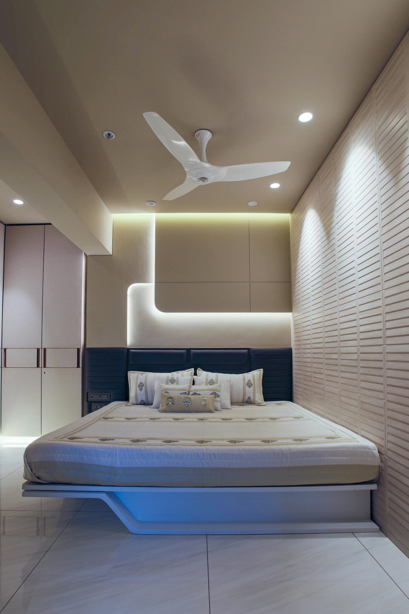 Explore this modern minimalist bedroom featuring a sleek design with a ceiling fan and ambient lighting.